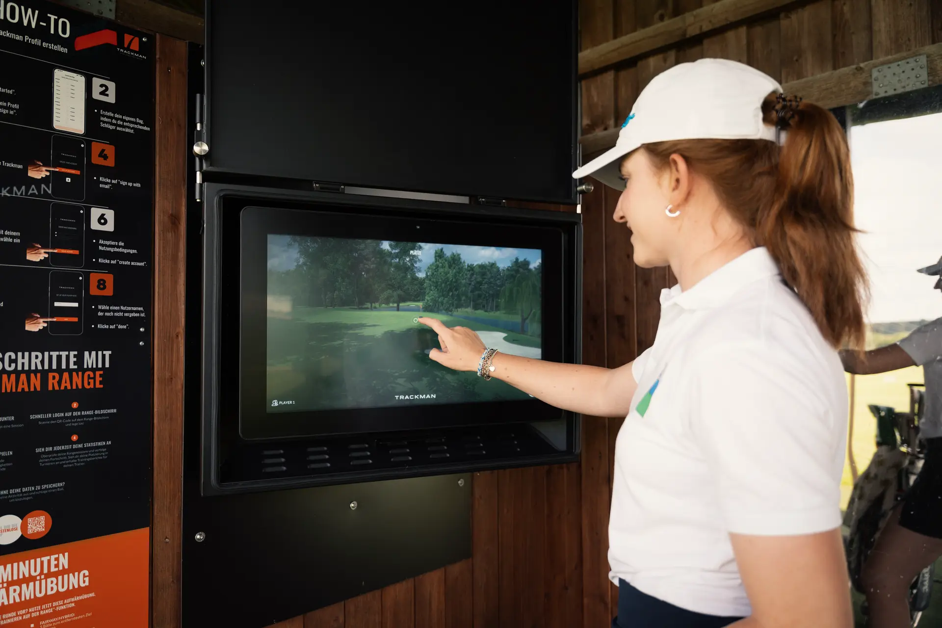 Interaktion der Golferin mit dem digitalen Display der Trackmann Range